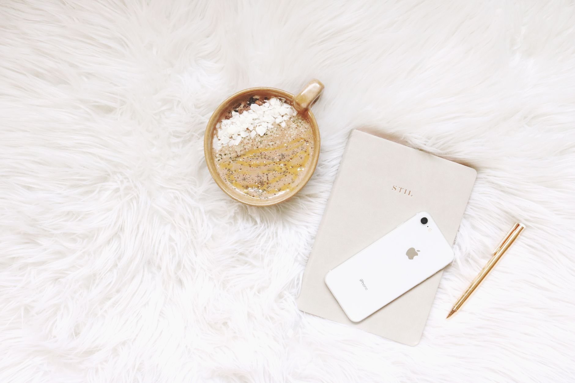 Minimalist flat lay of phone, notebook, and pen — the tools of a digital creator.